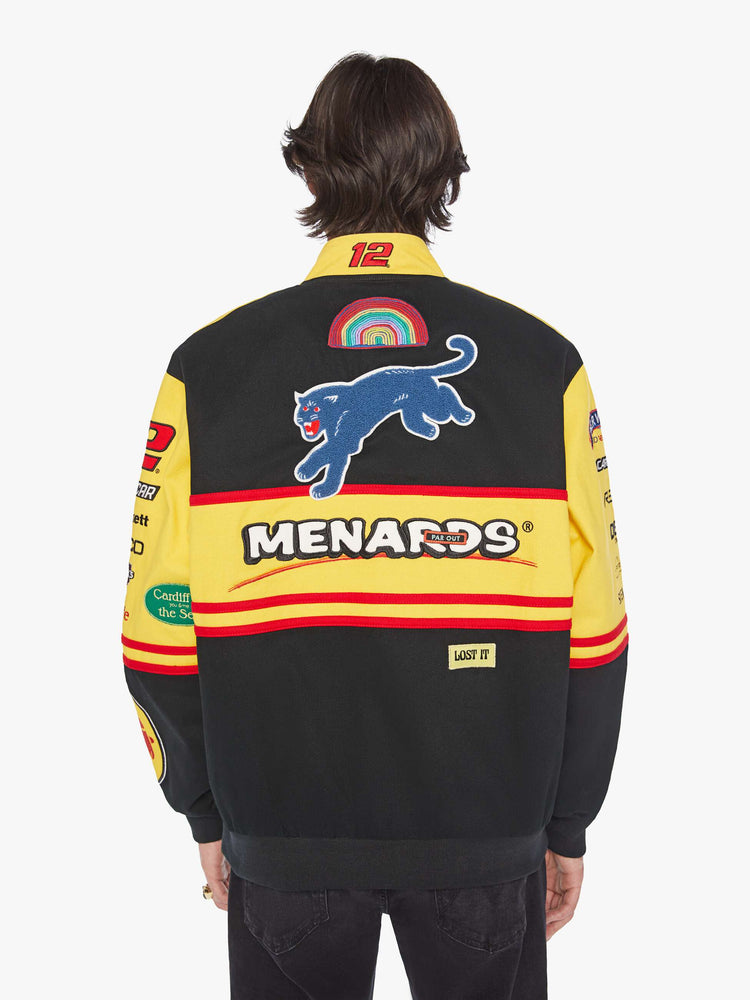 Back view of a men's racing jacket with drop shoulders, ribbed hems, snaps down the front and an oversized fit one of one combination of colors and patches inspired raceway logos.