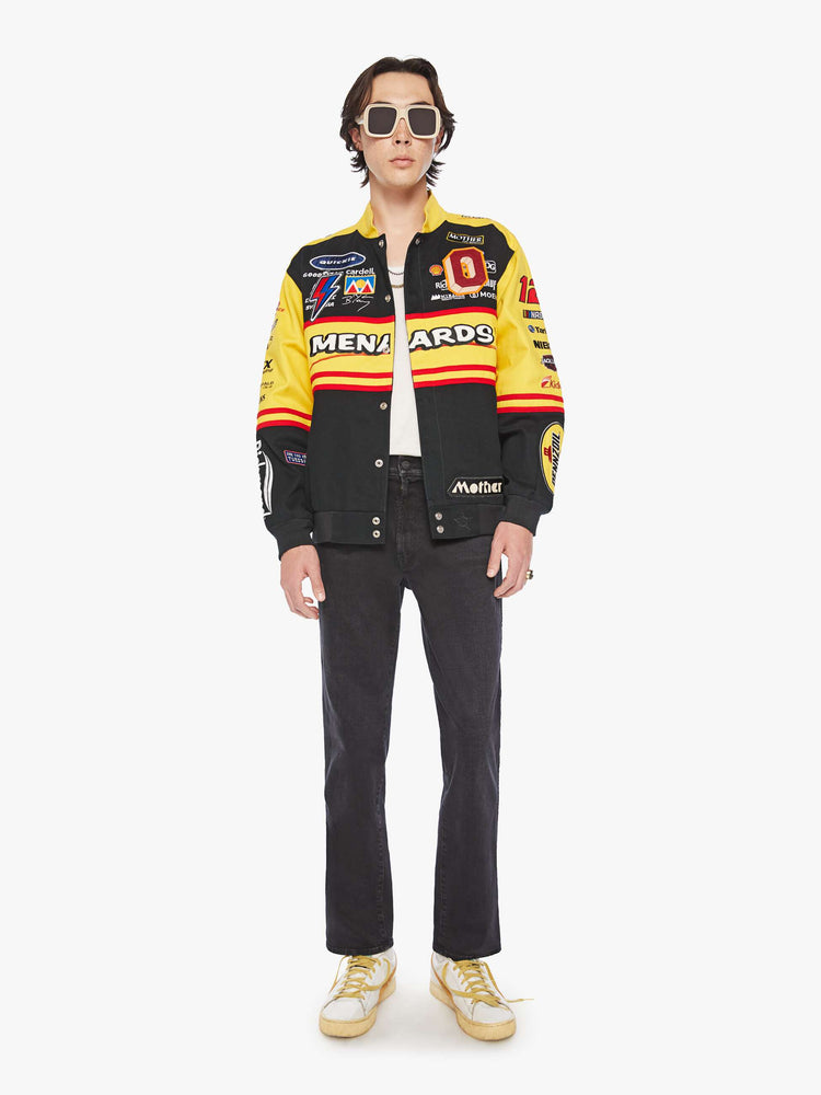 Full body view of a men's racing jacket with drop shoulders, ribbed hems, snaps down the front and an oversized fit one of one combination of colors and patches inspired raceway logos.