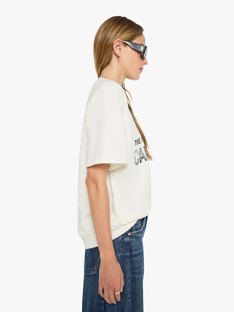 WOMAN side view in white tee features faded text and a red skydiver graphic on the front.
