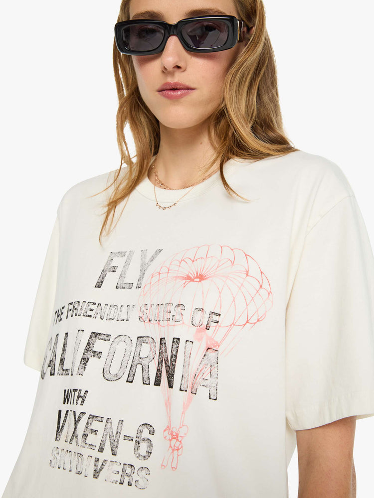 WOMAN close up view in white tee features faded text and a red skydiver graphic on the front.