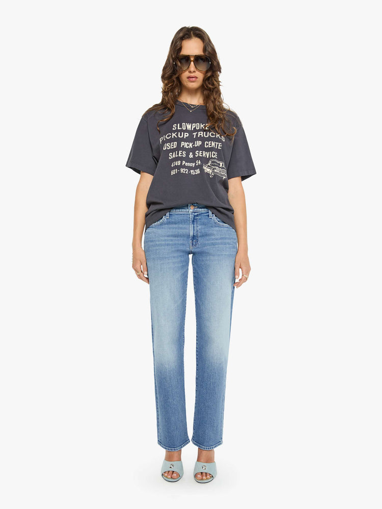 WOMAN full body view in a dark grey oversized tee features a crackled text graphic and pickup truck in white on the front.
