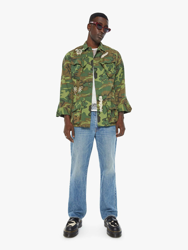 Front full body view of a mens camo jacket featuring front patch pockets and white embroidery details.