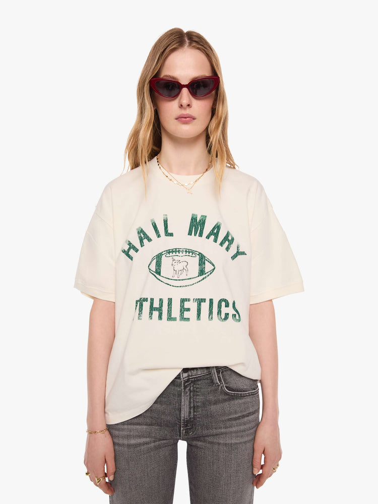 WOMAN front view of an off-white tee with a faded, vintage-inspired green football graphic with text on the front.