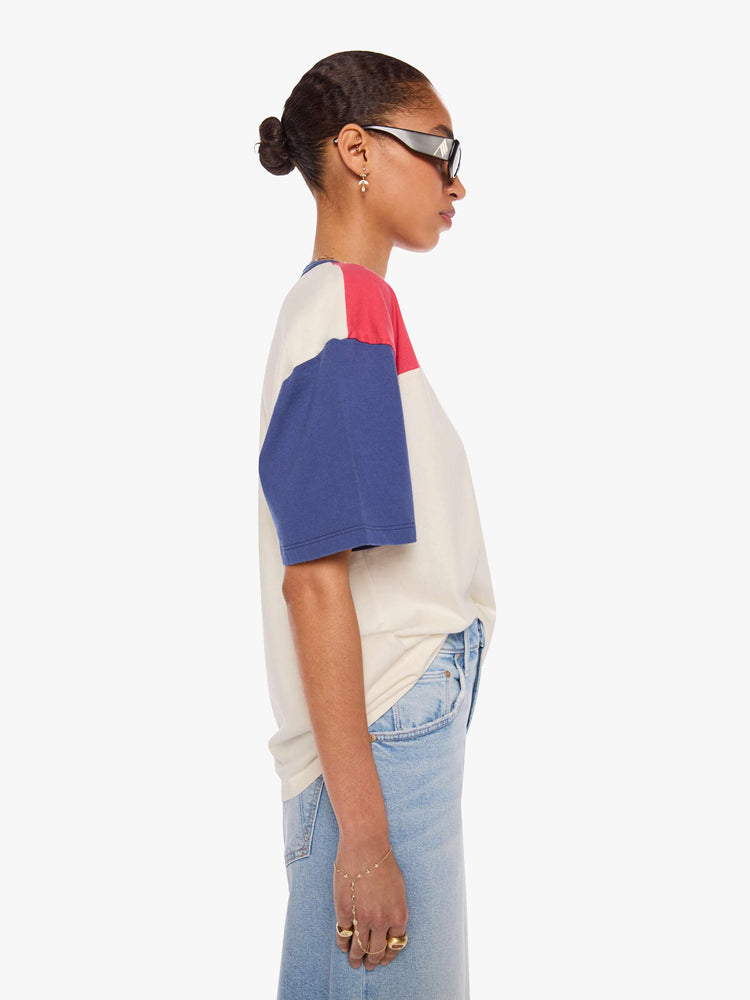 WOMAN side view in a white tee features blue sleeves and trim and a red panel across the chest.
