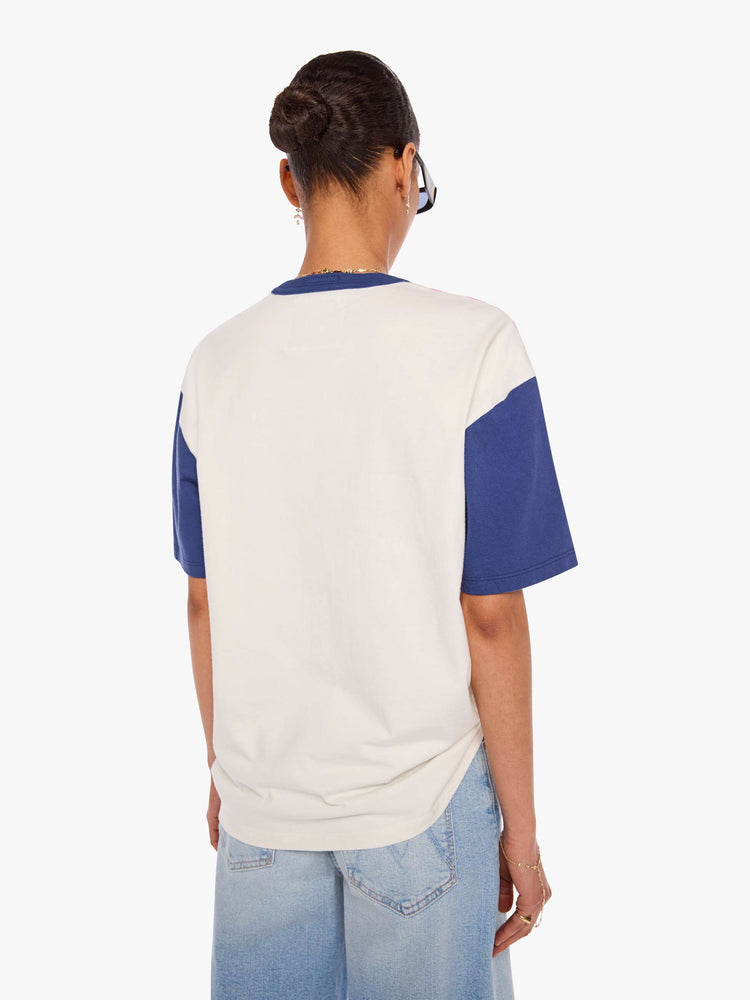 WOMAN back view in a white tee features blue sleeves and trim and a red panel across the chest.