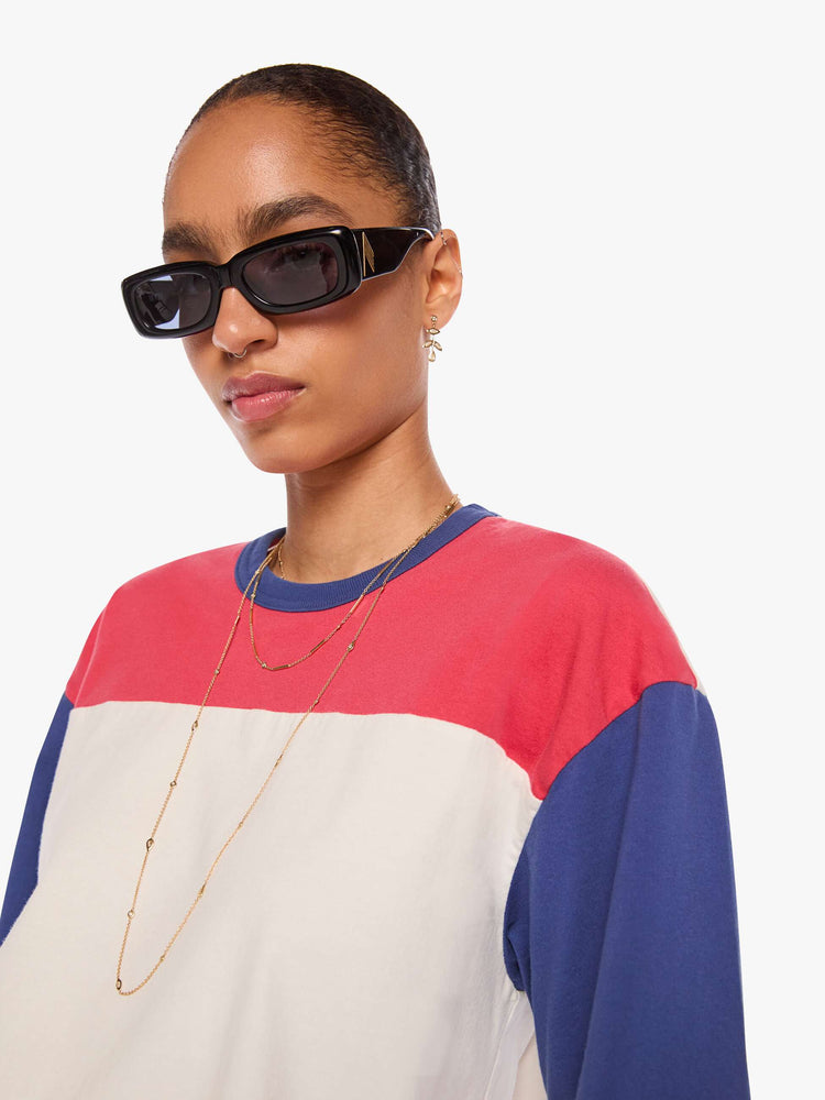 WOMAN close up view in a white tee features blue sleeves and trim and a red panel across the chest.