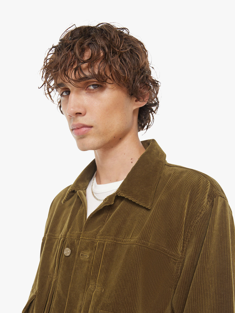 Close up view of a man button-up with oversized patch pockets, drop shoulders, extra-long sleeves and a loose fit. 