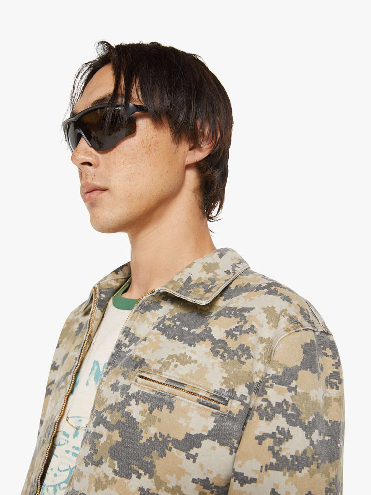 Close up view of a man in a faded zip-up jacket with a front slit pocket and a boxy fit.