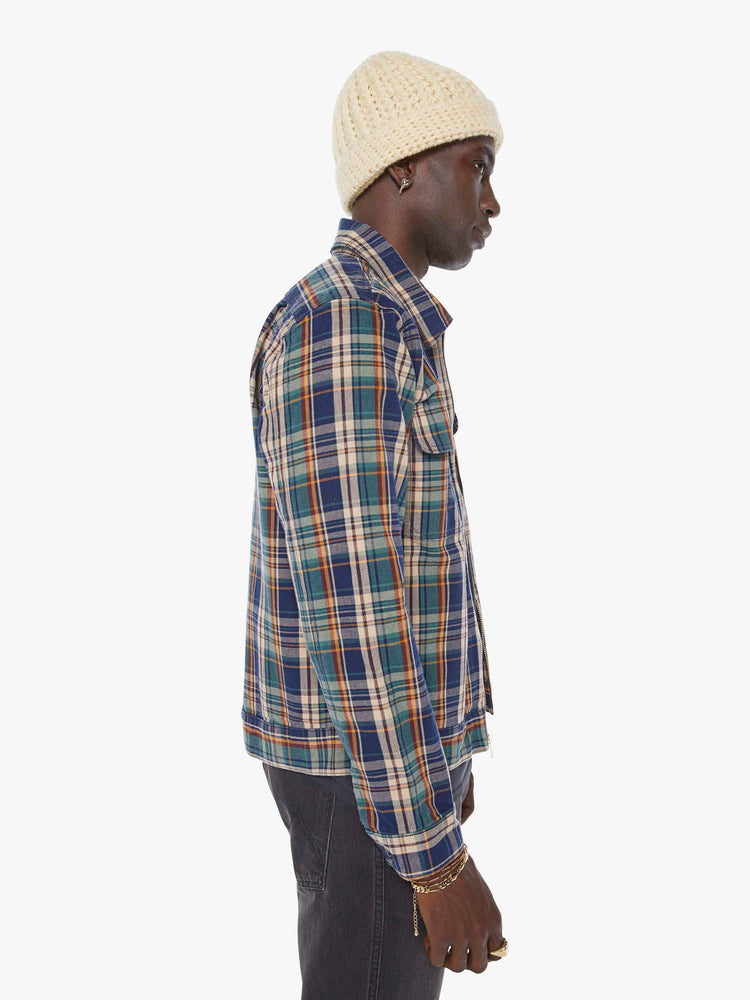 Side view of a man in a plaid print zip-up jacket with patch pockets, long sleeves and a slightly cropped fit. 