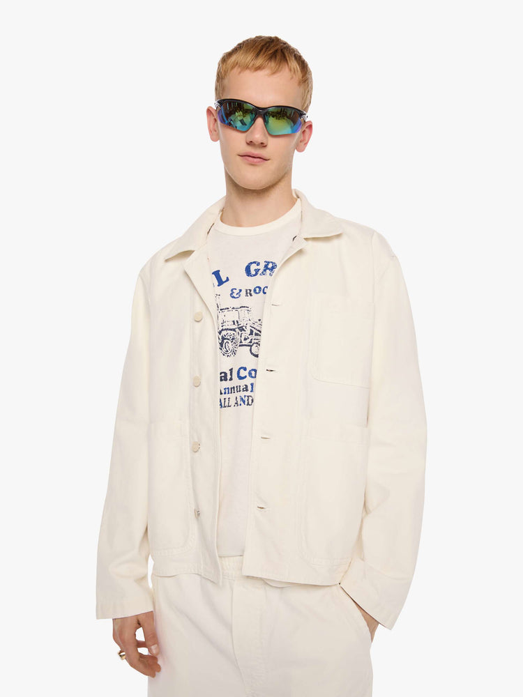 Front view of a man in a jacket designed in cream with tonal buttons down the front.