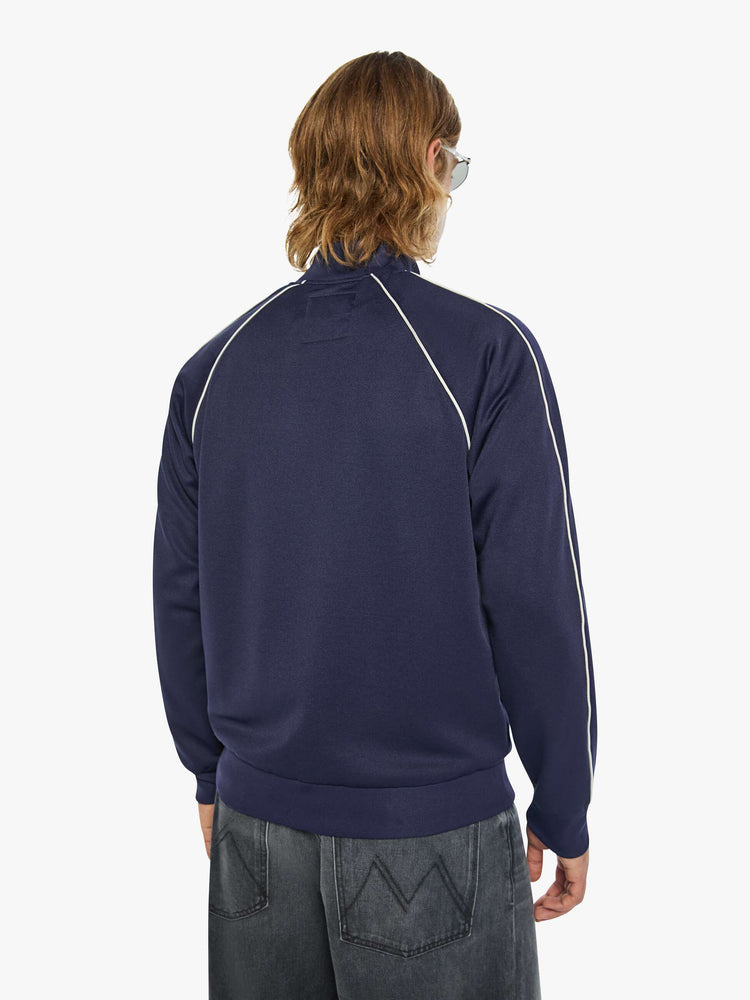 Back view of a man in a vintage-inspired sports jacket with a stacked collar, slit pockets, zip closure and a loose, comfortable fit.