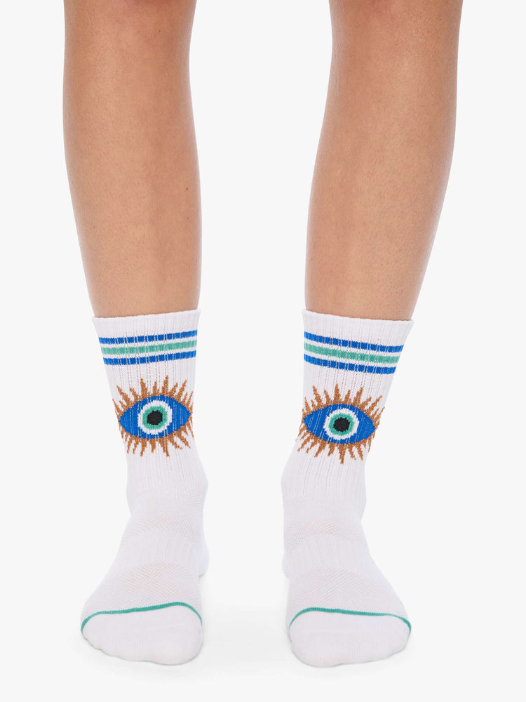 On model view of tube socks designed in white with a blue eye on the front and stripe detailing.