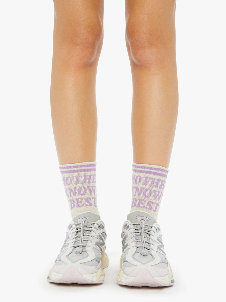 On model view of a vintage tube sock in cream with lavender lettering.