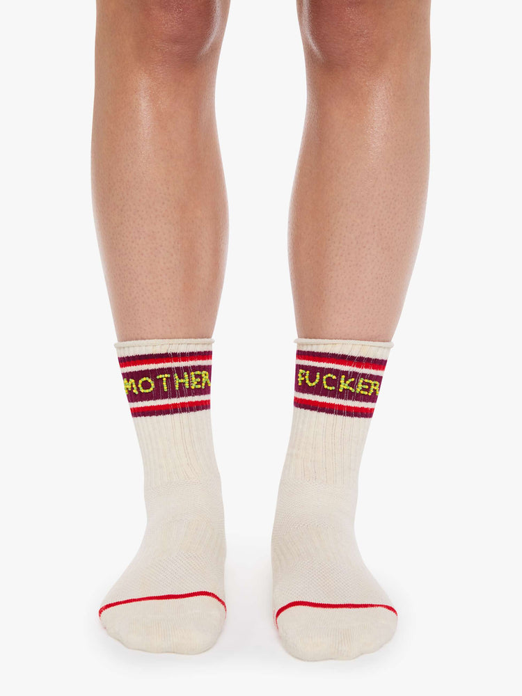 On model view of tube socks in cream with burgundy and red stripes and an explicit message from MOTHER spelled out in yellow and green beads.