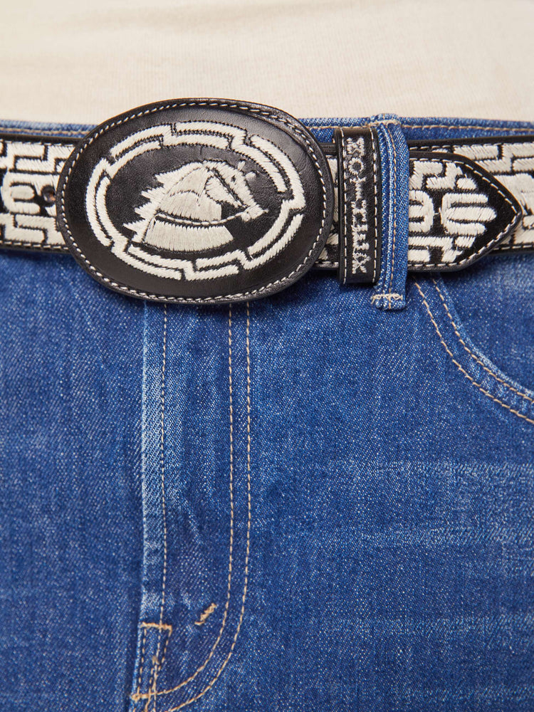 Close up view of leather belt with an oversized buckle and stitched details.
