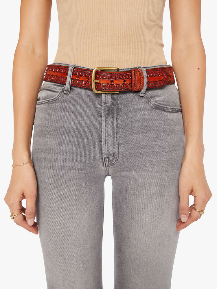 On model view of a  vintage-inspired leather belt with embossed and beaded details. 