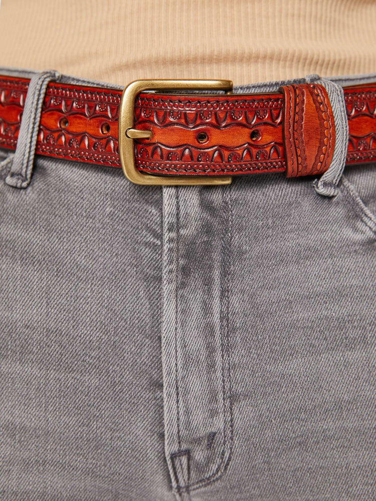 Close up view vintage-inspired leather belt with embossed and beaded details. 