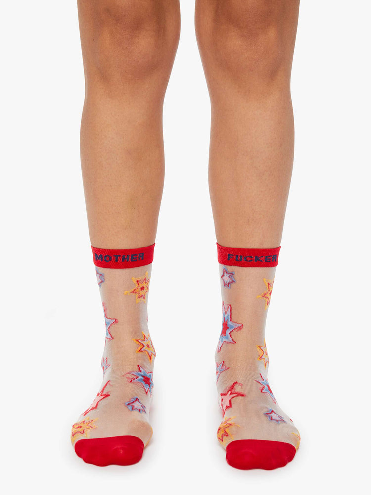 Front view of a twist on classic tube socks, The Step Up in Kaboom is designed in a translucent white fabric with colorful stars, red trim and navy text.