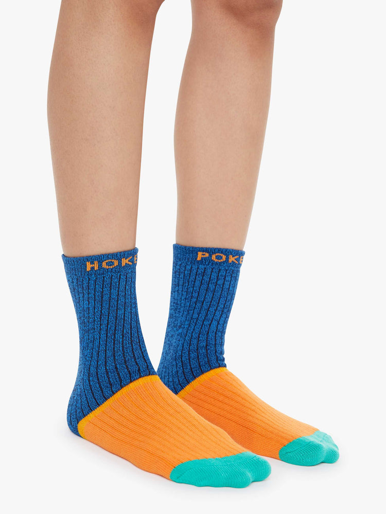 On model view of Hokey Pokey a pair of navy, orange and teal tube socks with text across the top.