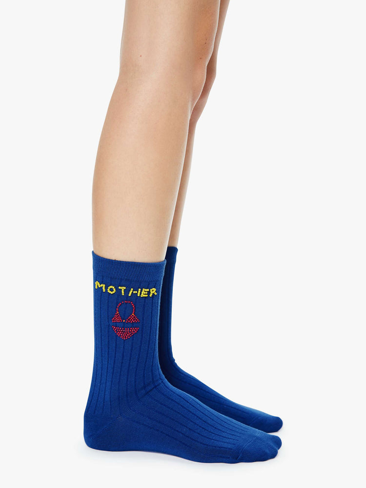 Side on model view of tube socks designed in blue with a sun, red bikini and MOTHER's name beaded on the sides.
