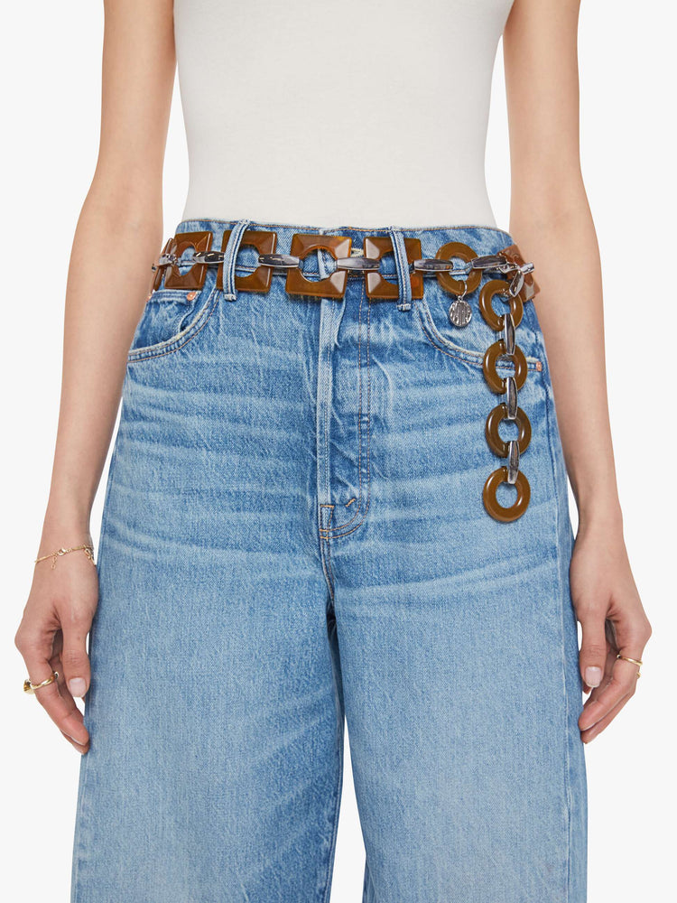 On model chunky belt featuring brown square and circular resin pieces connected by metal links.