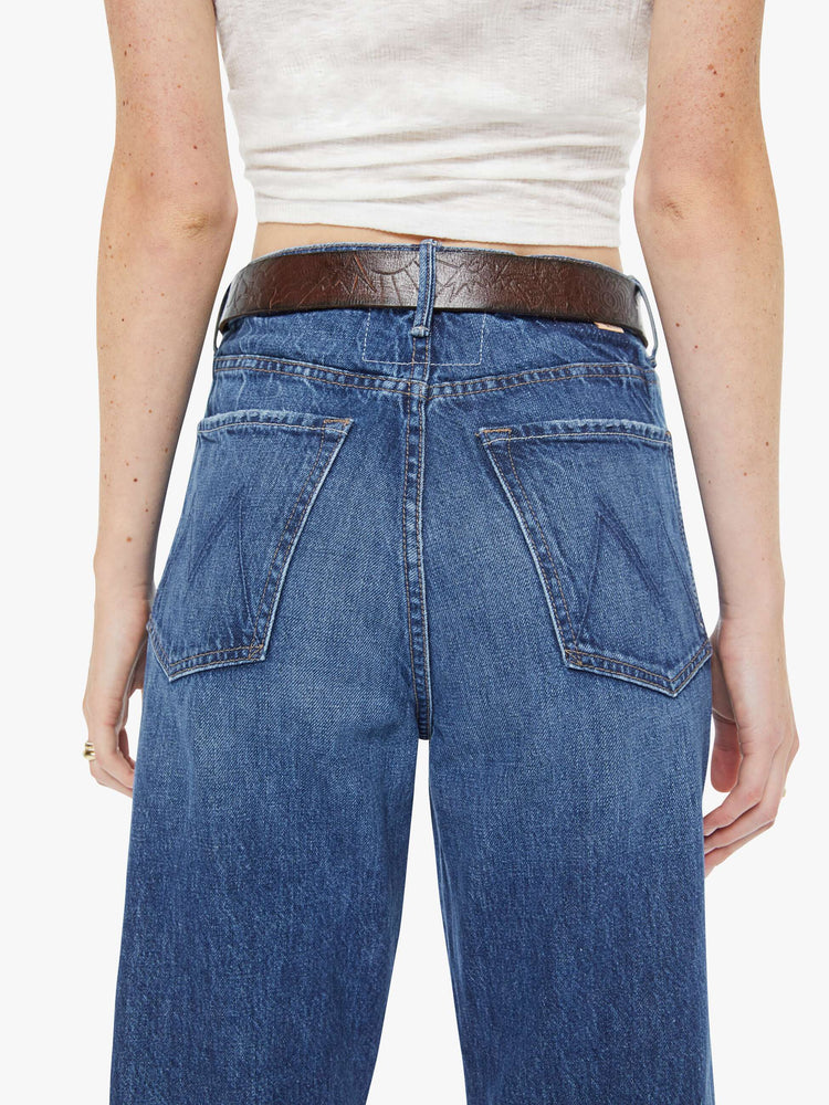 Back on model  view of a leather belt with an oversized brass buckle.