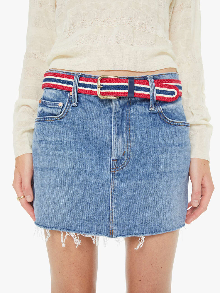 On model view of a belt in shiny gold-colored buckle and vintage vibe in red, white and navy stripes.