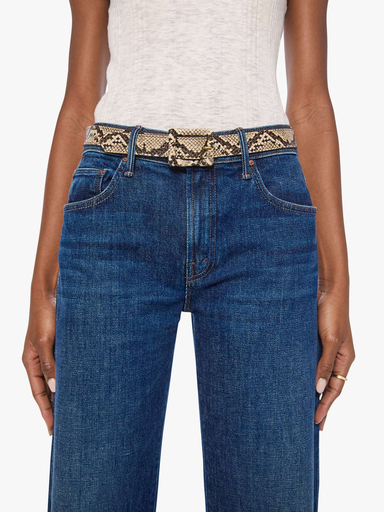 On model  view of a belt designed in faux snakeskin with an oversized rectangular buckle. 