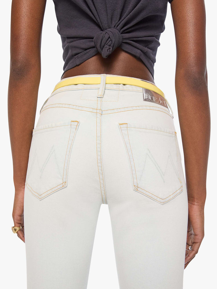 Back on model view of a narrow belt is made from 100% leather with a pastel yellow coating and silver hardware.