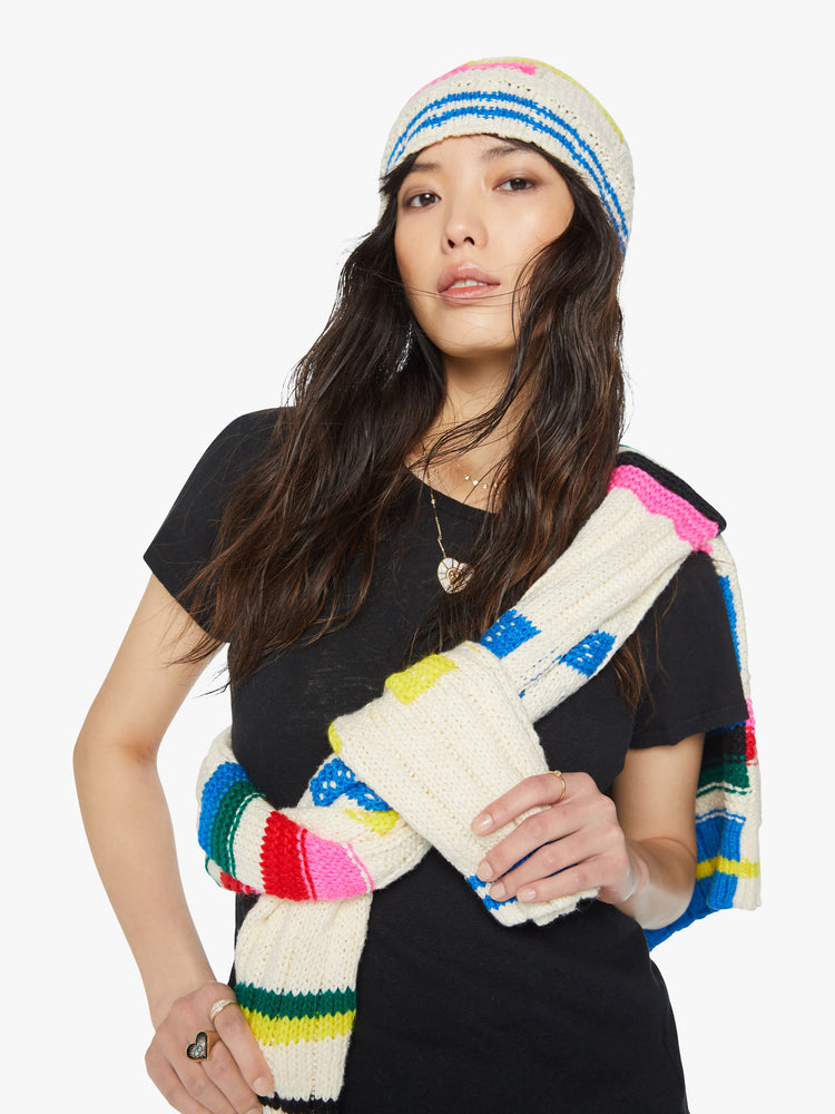 Front view a knit beanie with a ribbed hem and a snug fit in an off-white with colorful stripes, checks and cable knits details.