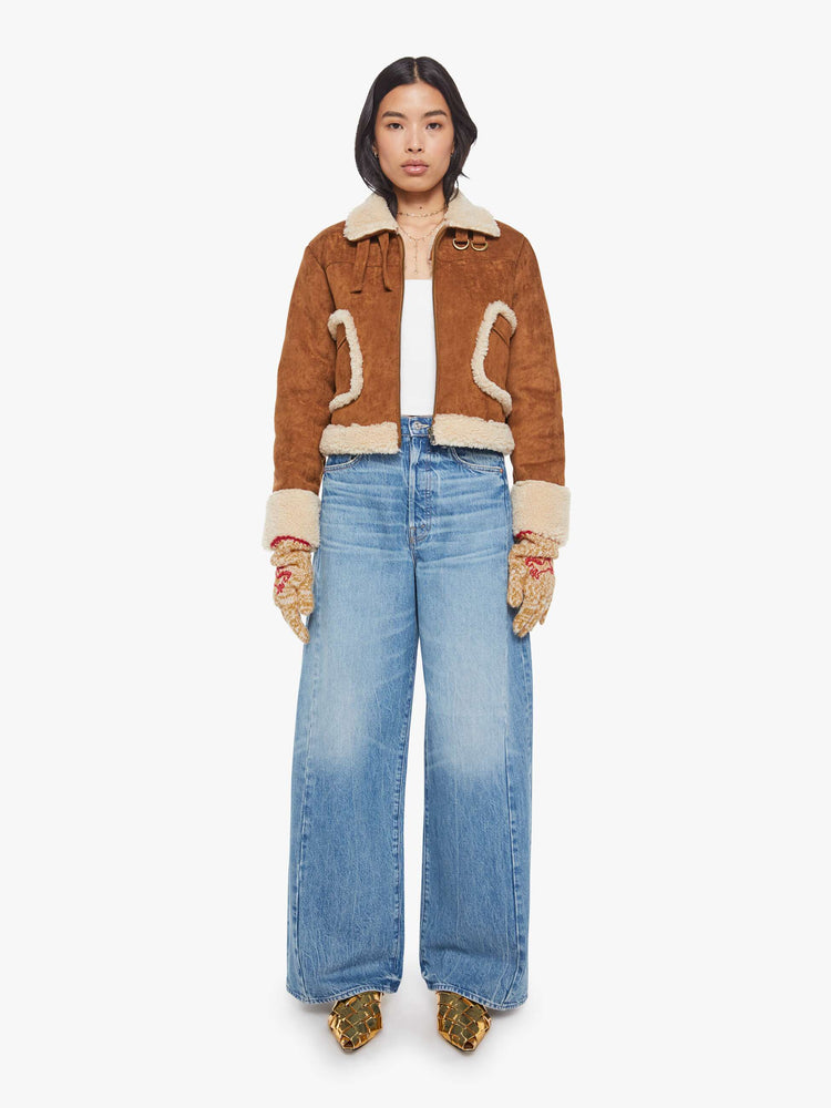 On model view of a woman in marled golden-yellow and white with red embroidered horses and trim gloves.