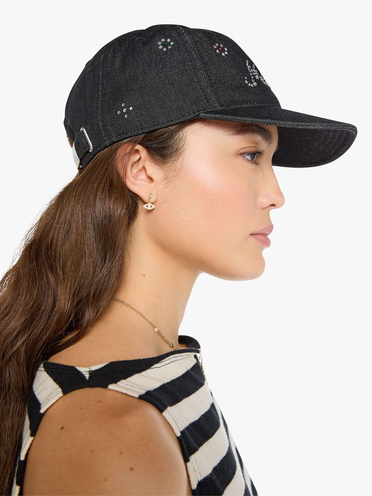 Side view of a woman in a dad hat designed in a faded black 100% cotton denim with MOTHER's name in rhinestones on the front.