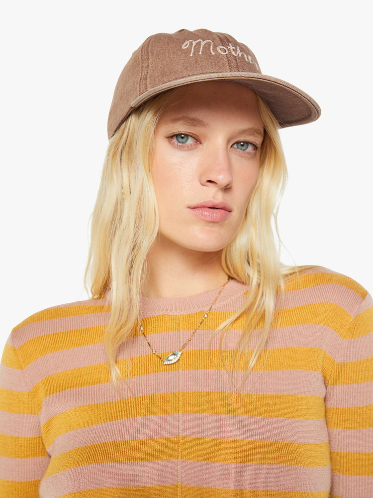On model dad hat designed in faded brown with MOTHER's name embroidered in white cursive on the front.