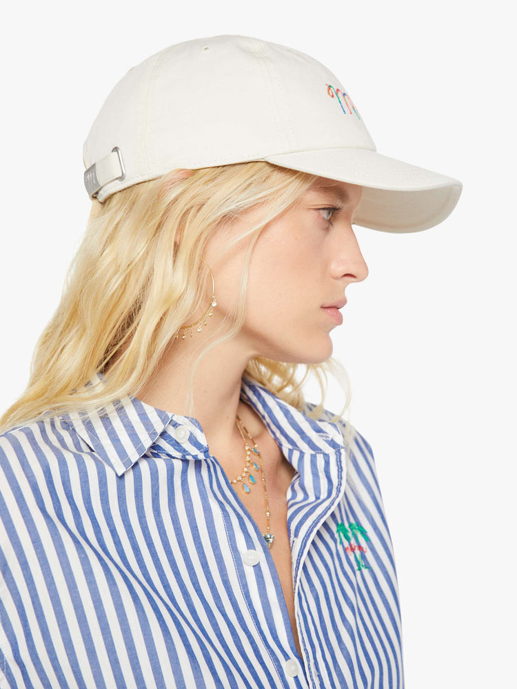 Side view of a woman in a dad hat designed in white 100% cotton with MOTHER's name embroidered in rainbow text on the front.