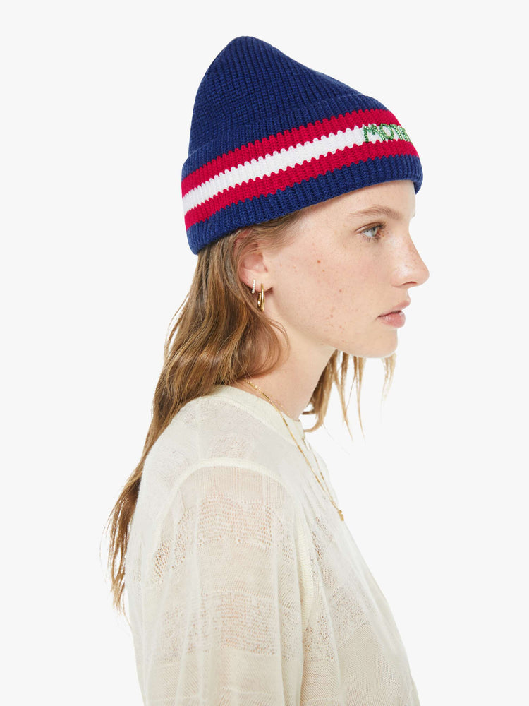 Side model view of a woman in a navy with red and white stripes, the beanie features MOTHER's name in green beads on the front.