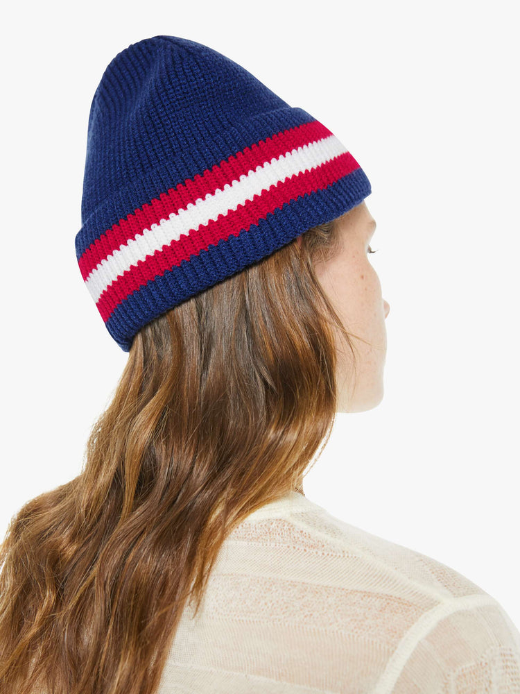 Back on model view of a woman in a navy with red and white stripes, the beanie features MOTHER's name in green beads on the front.