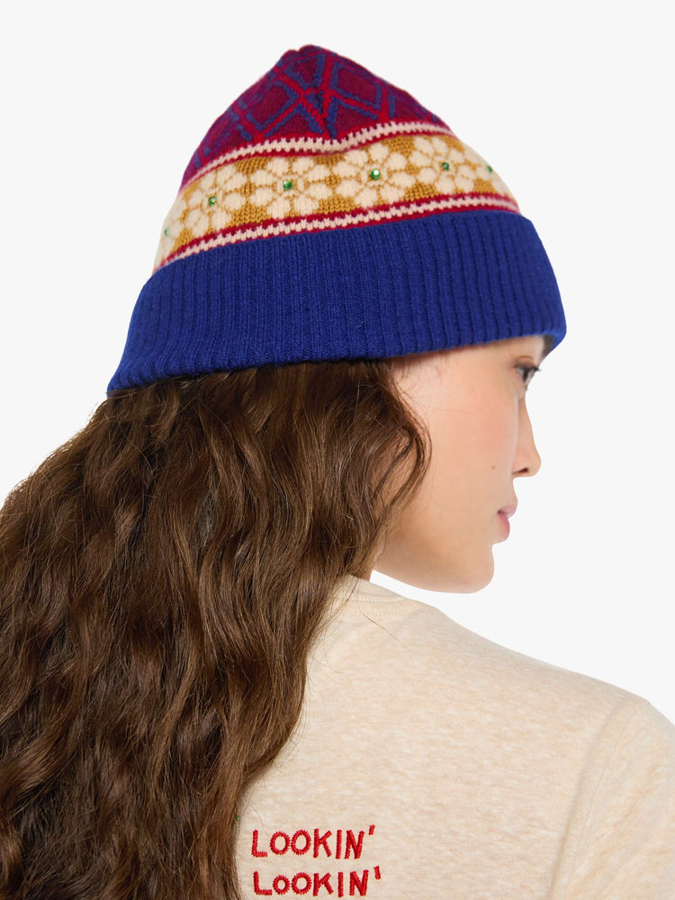 Side view of a woman in a knit beanie with a folded brim and small green rhinestone details.