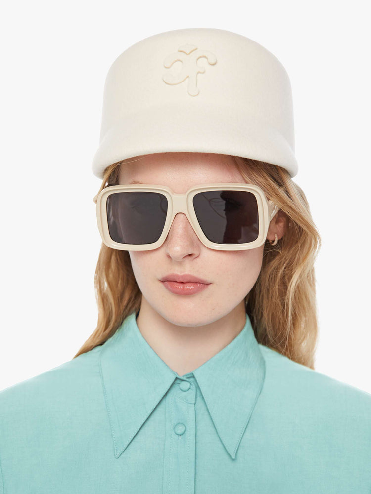 On model front view of a hat with a structured design and short brim.