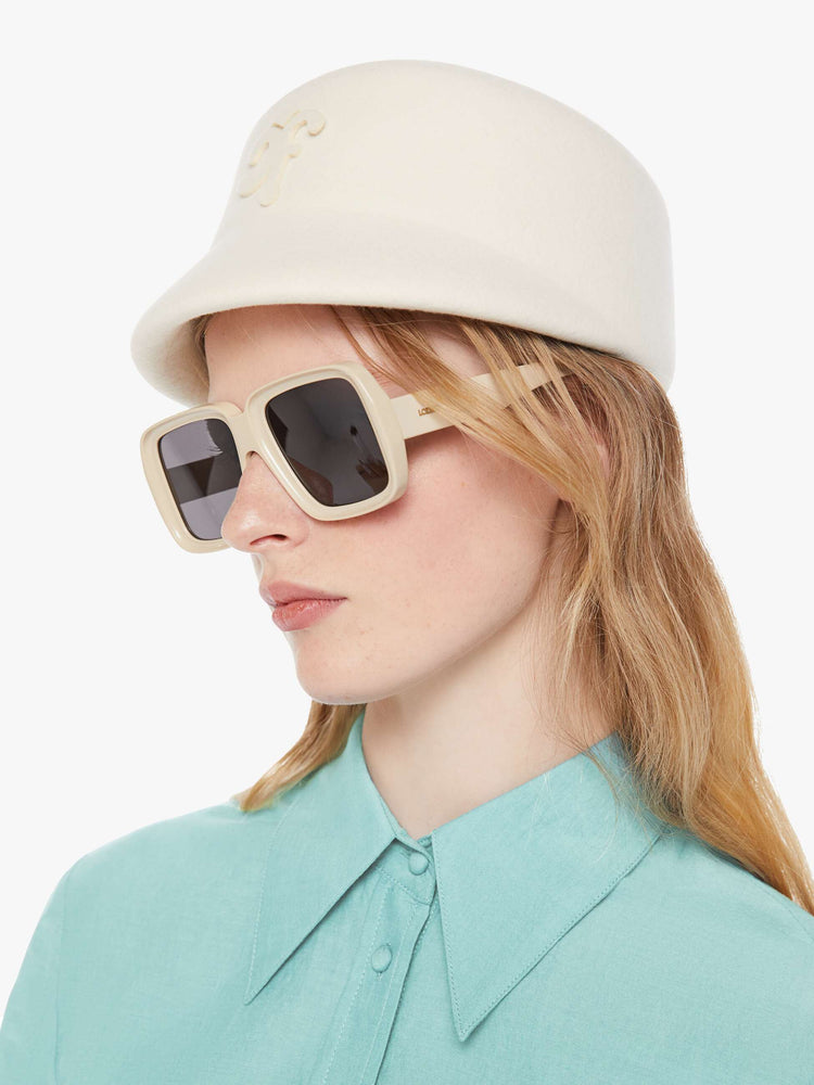 On model side view of a hat with a structured design and short brim.