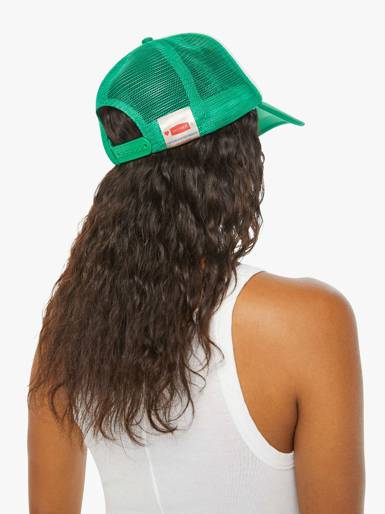 Back on model of a green and white trucker hat with a strawberry graphic and the word "MOTHER" in red.