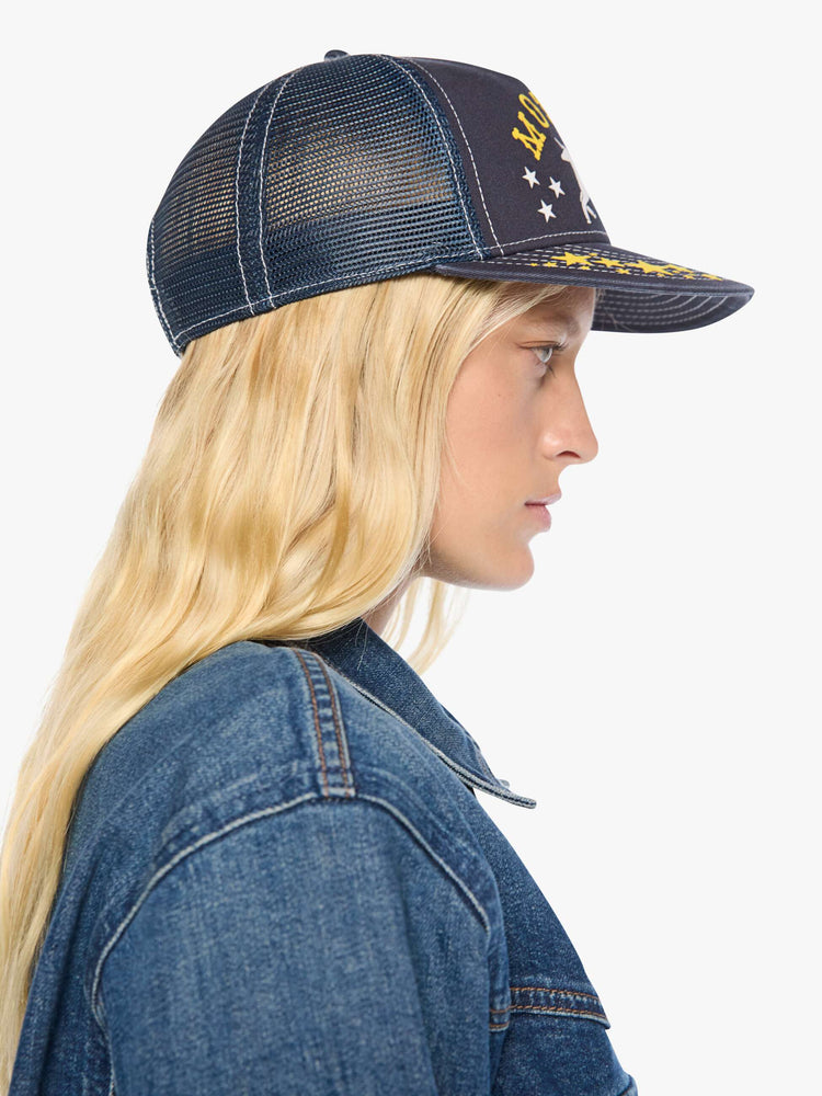 Side model view in a vintage-inspired trucker hat designed in navy with a Pegasus graphic and MOTHER's name in yellow on the front.