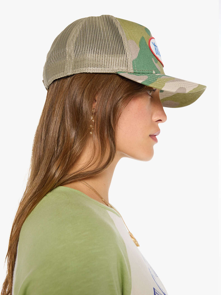 Side view of a vintage-inspired trucker hat designed in camo with an oversized white and red patch with MOTHER's name in blue on the front.