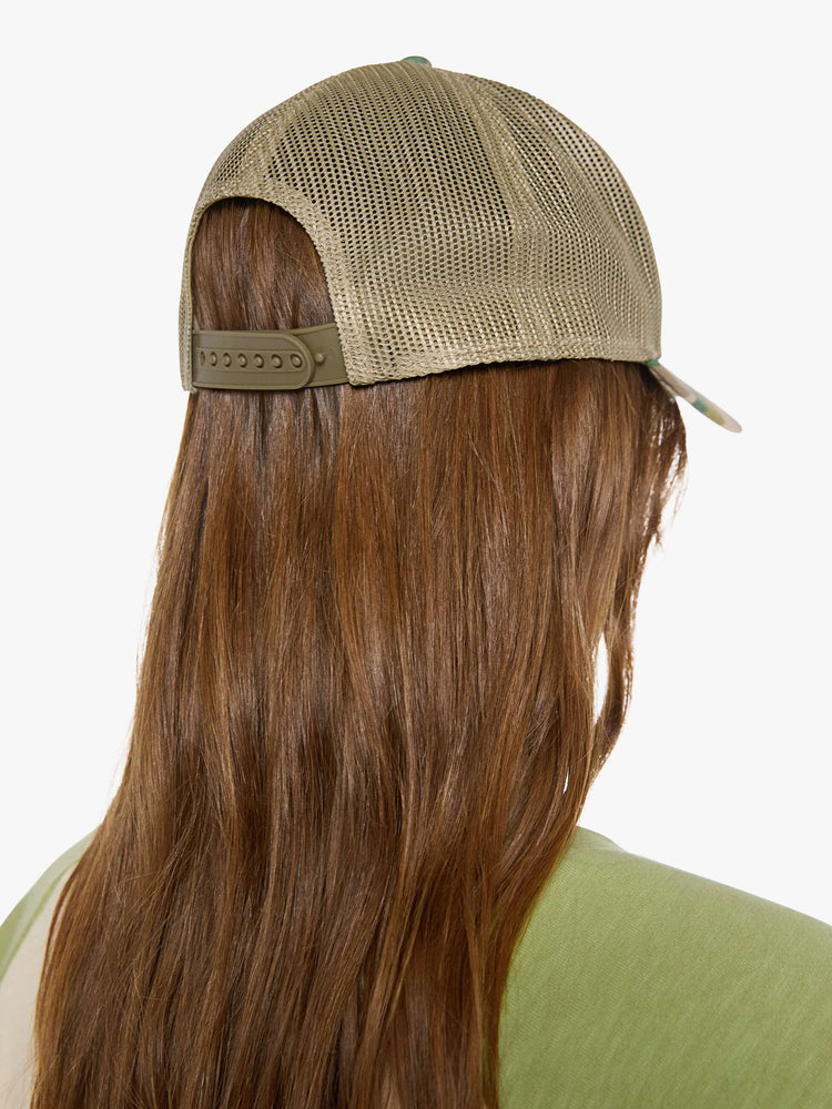 Back view of a vintage-inspired trucker hat designed in camo with an oversized white and red patch with MOTHER's name in blue on the front.