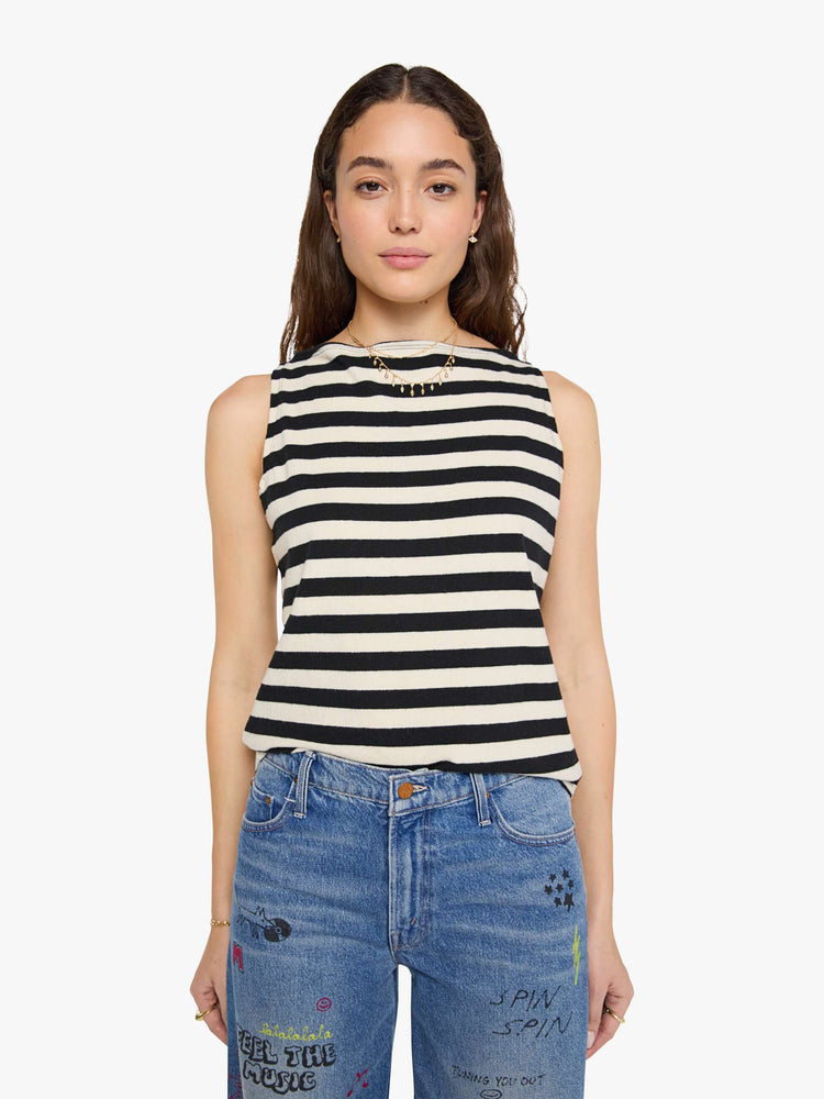 Front view of a woman in a black and off-white stripes sleeveless top with a boat neck and a boxy fit. 