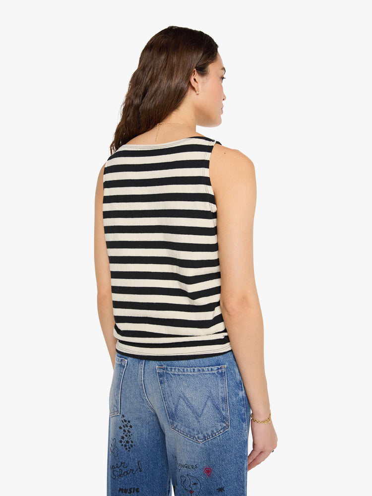 Back view of a woman in a black and off-white stripes sleeveless top with a boat neck and a boxy fit. 