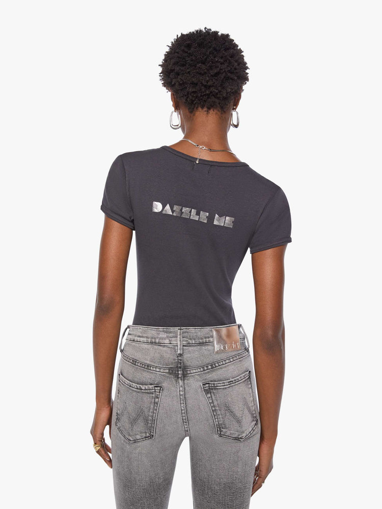 Back view of a woman in a shrunken crewneck tee with extra-short sleeves and a cropped hem in a faded black with a metallic text graphic on the front.