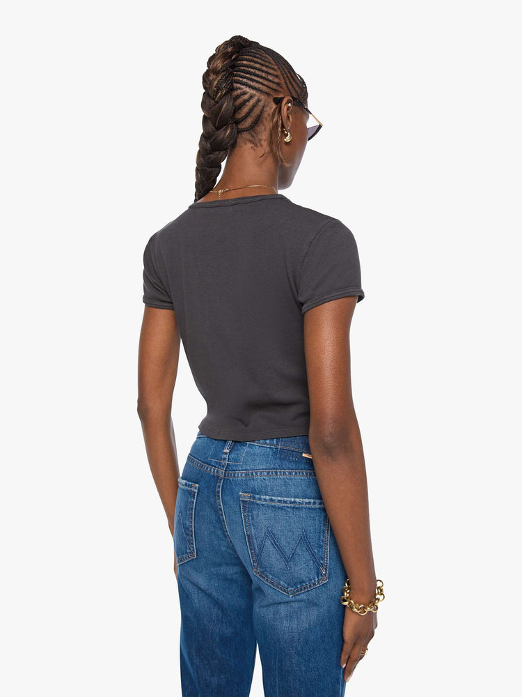 Back view of a woman in a faded black a smiling mouth graphic and MOTHER's name in golden yellow on the front.