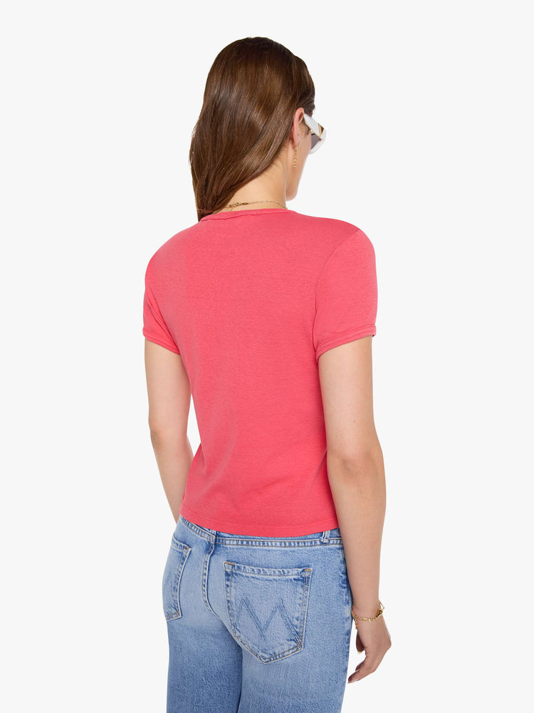 Back view of a woman in a coral crewneck tee with extra-short sleeves and a cropped hem.
