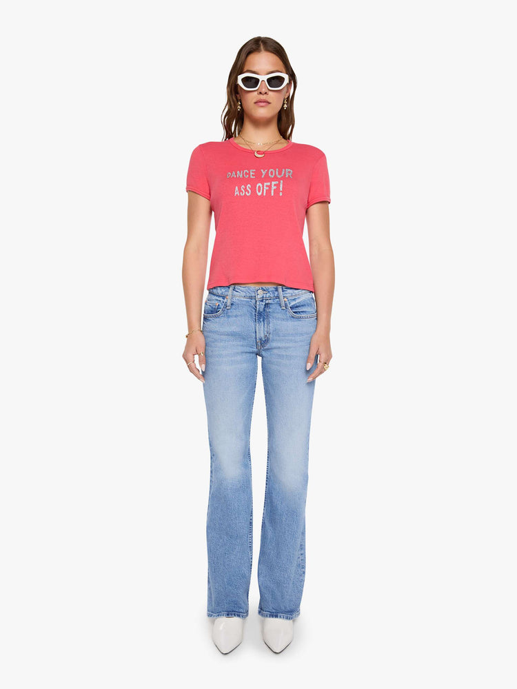 Full body view of a woman in a coral crewneck tee with extra-short sleeves and a cropped hem.