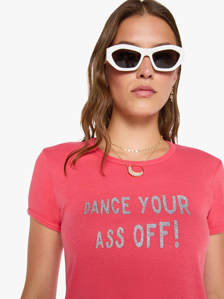 Close up view of a woman in a coral crewneck tee with extra-short sleeves and a cropped hem.